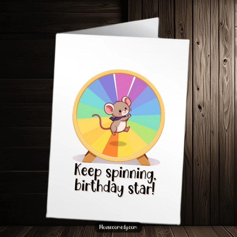 Funny free printable birthday card: a playful mouse energetically runs on a giant, vibrant hamster wheel.